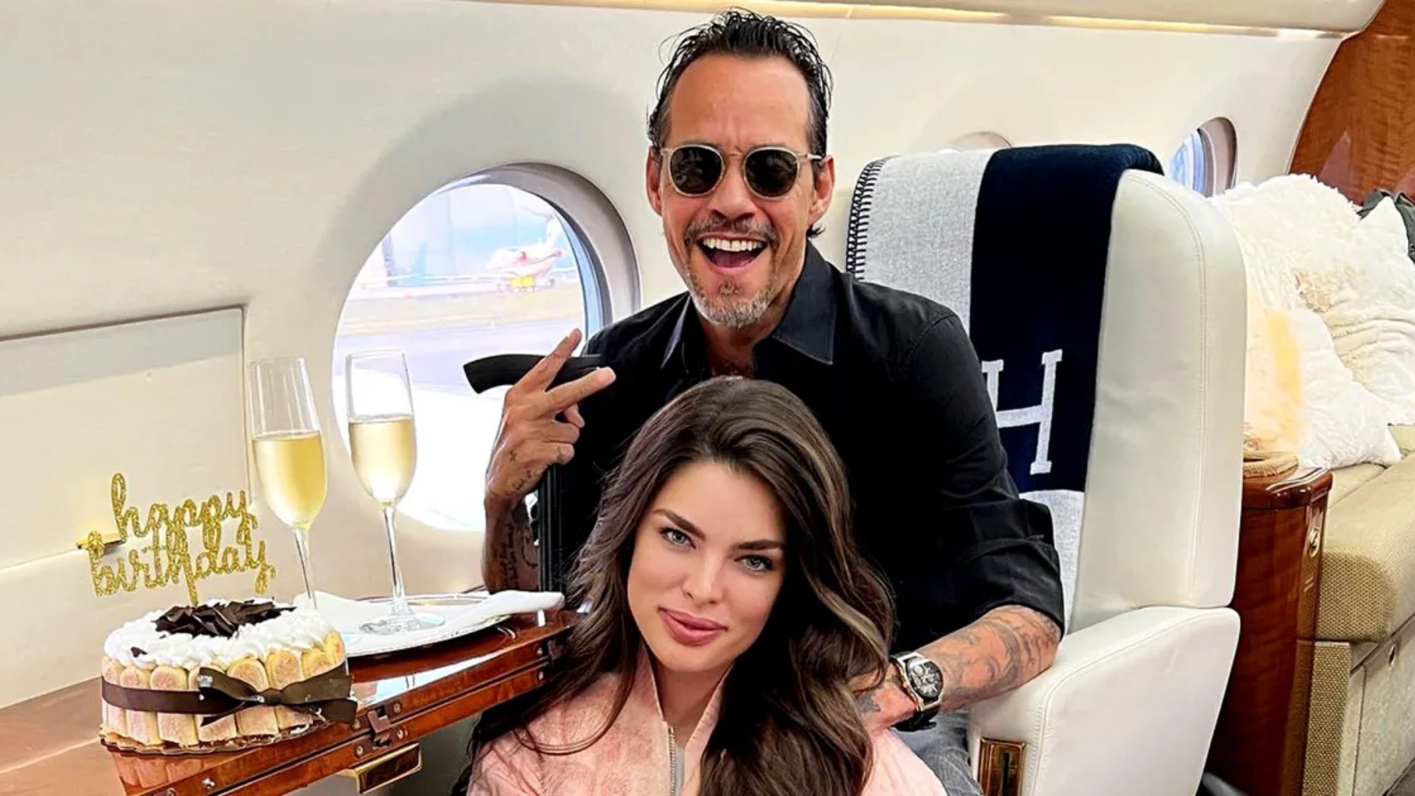 Marc Anthony y Nadia Ferreira posan en un avión