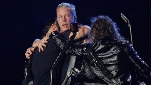 James Hetfield al momento de ser abrazado por todos los miembros de...