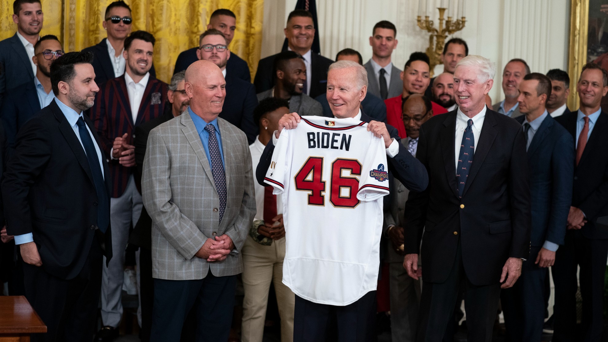 El presidente Joe Biden sostiene una camiseta durante un evento que celebró al campeón de la Serie Mundial 2021, Atlanta Braves.