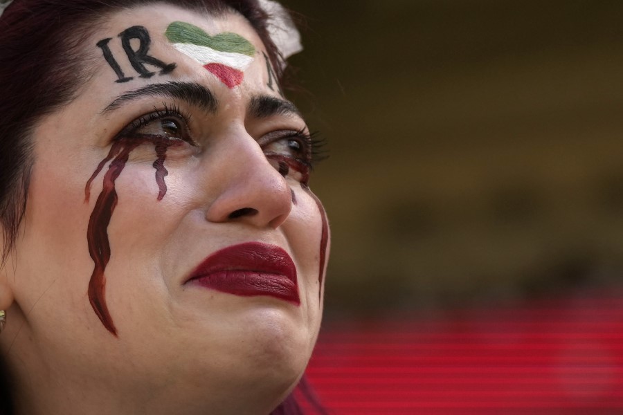 Mujer iraní llora luego de que la seguridad de Qatar le quitó su bandera previo al duelo ante Gales.