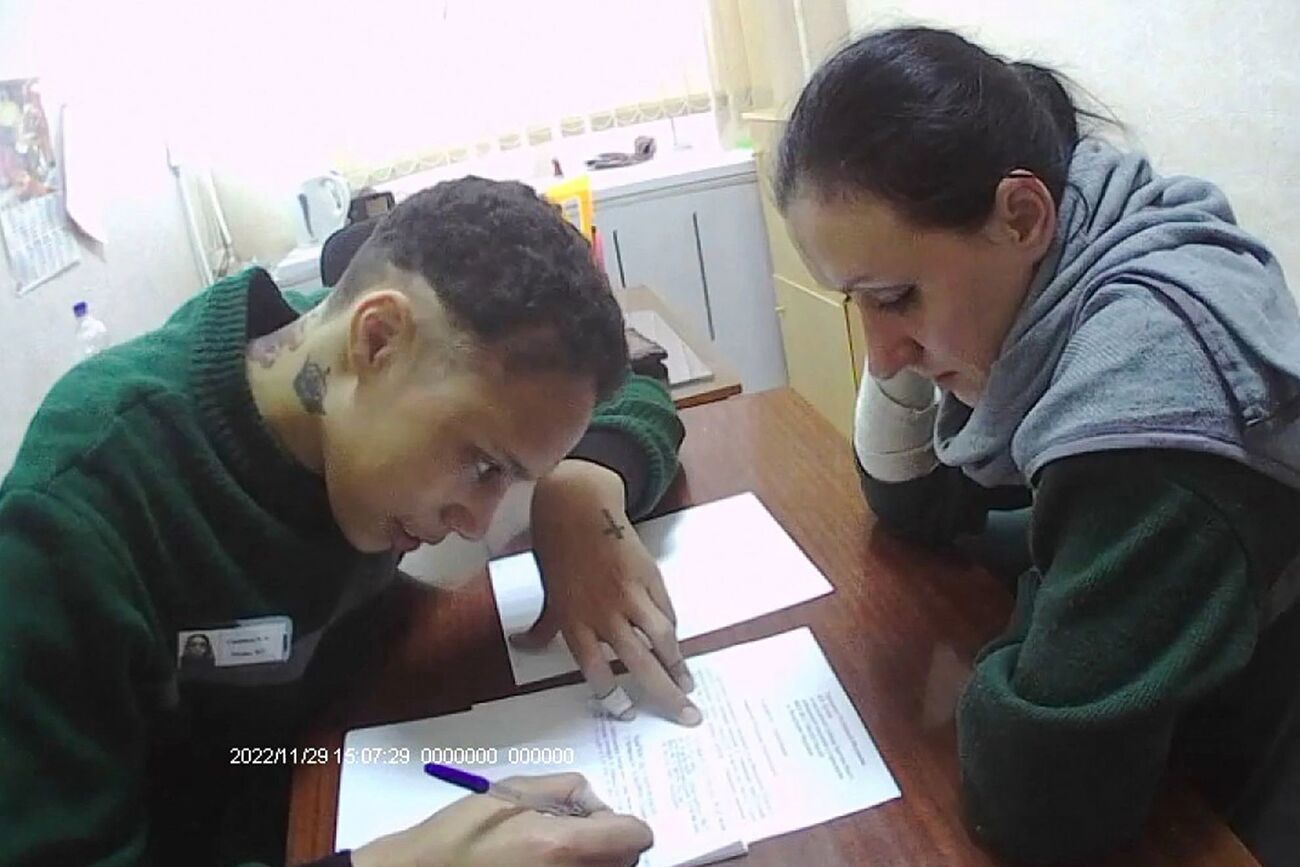 Griner firmando los papeles oficiales de liberacin desde el interior...