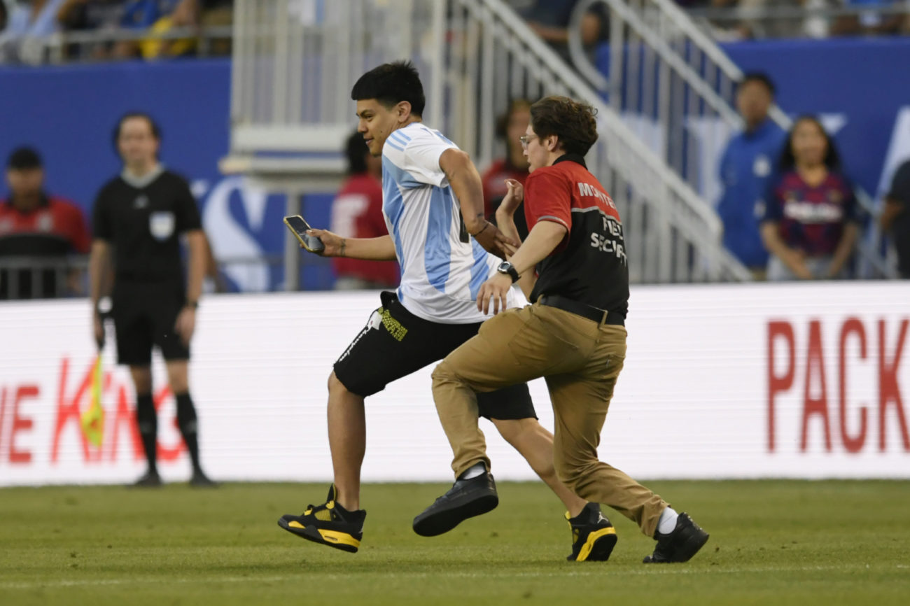 Un aficionado de Argentino salt al campo para tratar de alcanzar a...